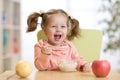 Cheerful baby child eating food itself with a spoon Royalty Free Stock Photo