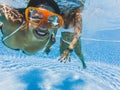 Cheerful happy beautiful people caucasian girl smiling underwater with friend - travel and play in the blue water pool together -