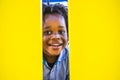 Cheerful happy black young boy children have fun and smile laughing at the park playhood with yellow wall space on sides for copy Royalty Free Stock Photo
