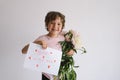 Cheerful happy child with Peonys bouquet and a card for mom in Ukrainian language.