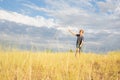 A cheerful, happy child runs through a summer field with yellow grasses against a blue cloudy sky. Royalty Free Stock Photo