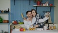 Cheerful happy couple having online video chat using smartphone in the kitchen at home in the morning Royalty Free Stock Photo