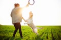 Cheerful and happy dog labrador retriever plays with his young woman owner on a green field on the sunset at spring. The dog Royalty Free Stock Photo