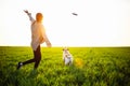 Cheerful and happy dog labrador retriever plays with his young woman owner on a green field on the sunset at spring. The dog Royalty Free Stock Photo