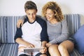 Cheerful and happy family at home studying on a tablet internet connected. bright image of caucasian people mother and son