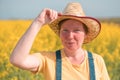 Cheerful happy female farmer agronomist in blooming rapeseed crops field on sunny spring day Royalty Free Stock Photo