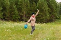 Cheerful happy fifty-year-old woman collects mushrooms in a bucket in the forest Royalty Free Stock Photo