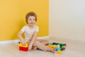Cheerful happy kid is playing with toys. A boy builds a construction kit at home spending time Royalty Free Stock Photo