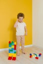 Cheerful happy kid is playing with toys. A boy builds a construction kit at home spending time Royalty Free Stock Photo