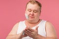 Happy plump man with shaving foam on his face and razor isolated on pink Royalty Free Stock Photo