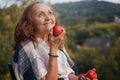 Cheerful happy mature senior woman holding red apples sitting in her garden Royalty Free Stock Photo