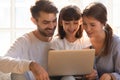 Cheerful mom dad and kid daughter using laptop at home Royalty Free Stock Photo