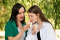 Mom and teenage daughter eat ice cream on walk Royalty Free Stock Photo
