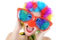 Portrait of a cheerful happy smiling clown with big funny glasses and red nose in studio Royalty Free Stock Photo