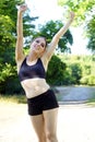 Cheerful happy smiling woman in sportswear posing after workout outdoors in nature Royalty Free Stock Photo