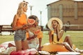 Cheerful happy three girls having a picnic with fruits outdoors Royalty Free Stock Photo