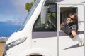 Cheerful happy toutist man smile and admire outside the driver windows of his modern white camper car motorhome. People and travel Royalty Free Stock Photo