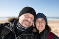 cheerful happy winter tourist couple middle aged taking selfie picture in vacation on coast beach sea with phone cell smartphone Royalty Free Stock Photo