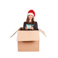 Cheerful happy woman in dress and christmas hat having fun while sitting in the big gift box and giving present witj blue ribbon. Royalty Free Stock Photo