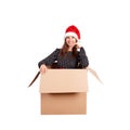 Cheerful happy woman in dress and christmas hat having fun while sitting in the big gift box and raises his hands up from happines Royalty Free Stock Photo