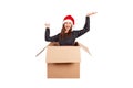 Cheerful happy woman in dress and christmas hat having fun while sitting in the big gift box and raises his hands up from happines Royalty Free Stock Photo