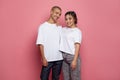 Cheerful happy woman and man in white t-shirt on pink studio wall background Royalty Free Stock Photo