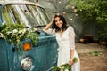 Cheerful happy young bride hold bouquet near retro-minibus. Close-up.