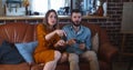 Cheerful happy young Caucasian couple play videogame against each other having fun at home, man is winning slow motion. Royalty Free Stock Photo