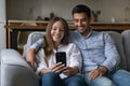 Cheerful happy young couple in love using mobile phone