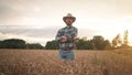 Cheerful and happy young man farmer in hat and plaid shirt smiling positively