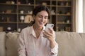 Cheerful happy young smartphone user woman reading text message