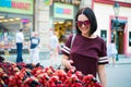 Cheerful happy young woman buying berries on a street market. Royalty Free Stock Photo