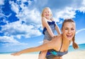 Cheerful healthy mother and child on seashore having fun time