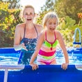Cheerful healthy mother and daughter in swimming pool playing Royalty Free Stock Photo