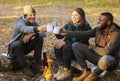 Cheerful hikers toasting for nice camping in sunset lights