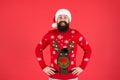 Cheerful hipster funny knitted sweater. warm clothes in cold winter weather. holiday season mood. bearded man santa hat Royalty Free Stock Photo