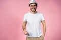 Cheerful hipster guy smiles happily, has excited expression, dresssed casually isolated over pink studio background