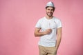 Cheerful hipster guy smiles happily, has excited expression, dresssed casually isolated over pink studio background