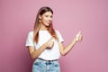 Cheerful hipster woman in white t-shirt making thumb up gesture and smiling joyfully, showing her support and respect to someone. Royalty Free Stock Photo