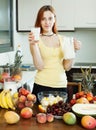 Cheerful housewife drinking milk cocktail with fruits Royalty Free Stock Photo