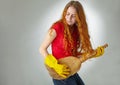 Cheerful housewife playing on her guitar broom. Royalty Free Stock Photo