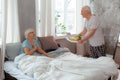 Cheerful husband bringing breakfast on the tray to the bed Royalty Free Stock Photo