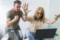 Cheerful husband and wife shopped from home using notebook and credit card while raising arms up Royalty Free Stock Photo