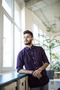 Cheerful indian business man standing near the window in modern office Royalty Free Stock Photo