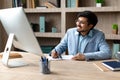 Cheerful Indian Businessman Working at Desk Computer In Office Royalty Free Stock Photo