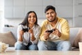 Cheerful Indian Couple At Home Playing Video Games With Joysticks Royalty Free Stock Photo