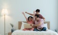 Cheerful indian family teenage boy son and girl with dad smiling and raising hands together while relaxing and using laptop Royalty Free Stock Photo