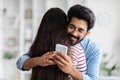 Cheerful indian guy chatting while hugging his girlfriend Royalty Free Stock Photo