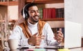 Cheerful Indian Tutor Having Virtual Class Sitting At Laptop Indoor