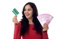 Cheerful Indian woman holding a bunch of Indian rupee and credit